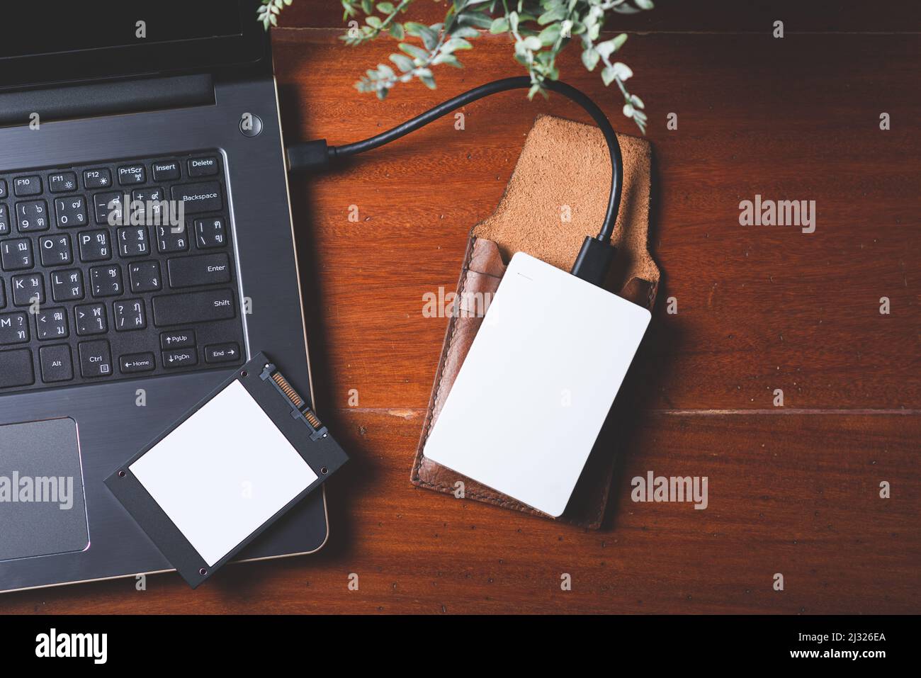 Closeup external hard drive on wooden desktop. Working with external hard drive. Stock Photo