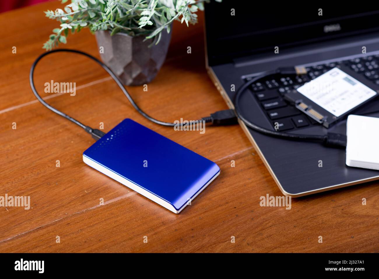 Closeup external hard drive on wooden desktop. Working with external hard drive. Stock Photo