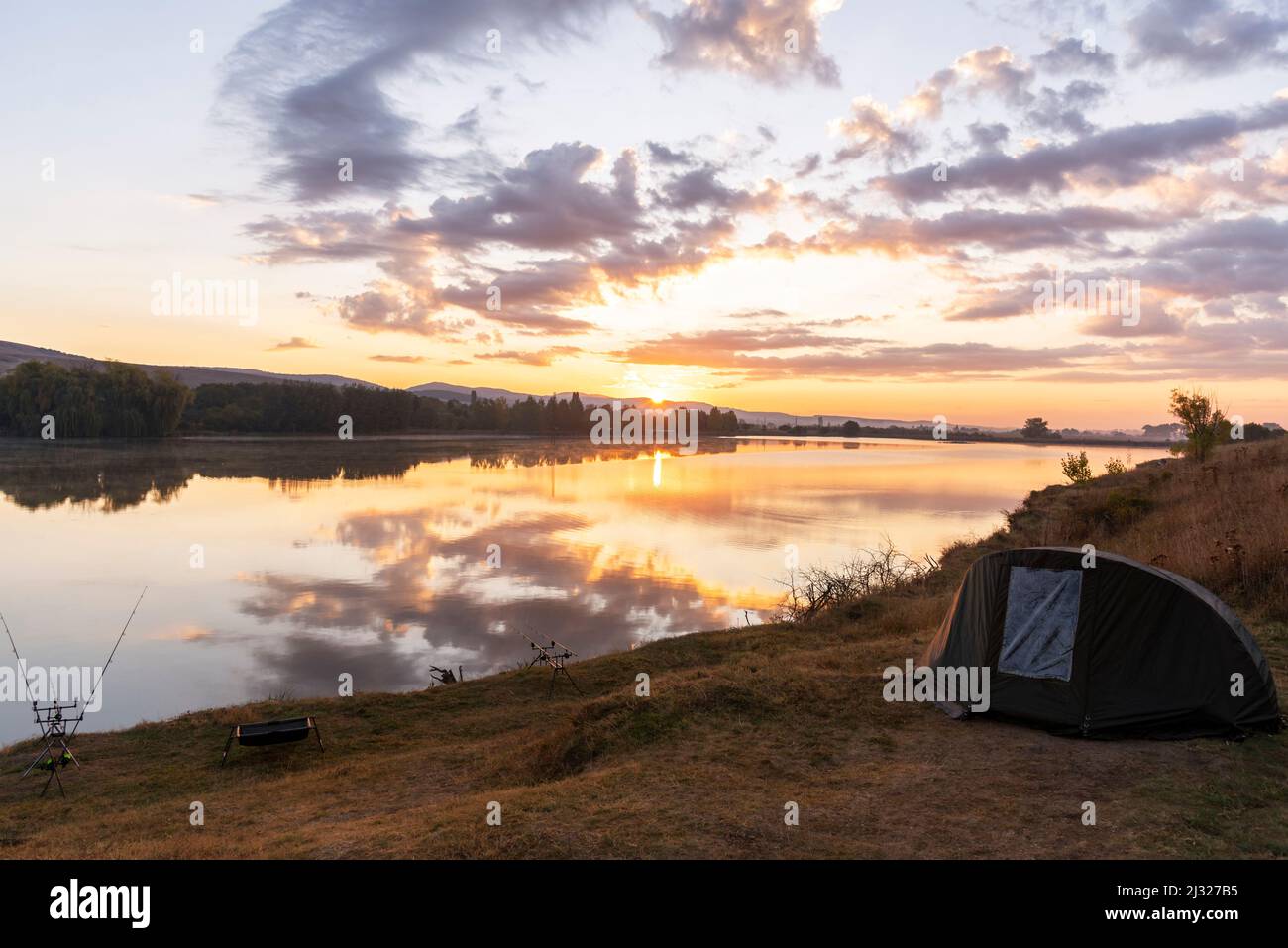 Rods with bite indicators and reels set up on rod pod on background of lake  or river in the morning close up Stock Photo - Alamy