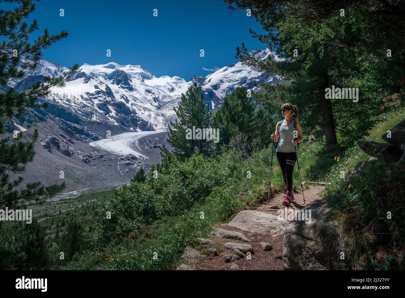 Woman hikes on path on Morteratsch Glacier in the Engadin in the Swiss Alps in summer Stock Photo