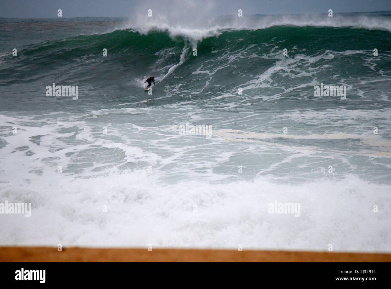 ein Big Wave Surfer am Nordstrand von Nazare, Portugal. Stock Photo