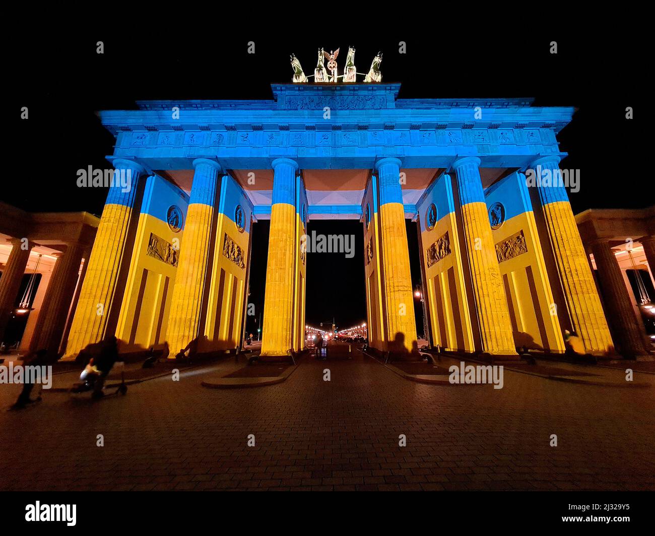 das Brandenburger Tor wird als Zeichen der Solidaritaet mit der Ukraine in dessen Landesfarben angestrahlt/ the Brandenburg Gate is being illuminated Stock Photo