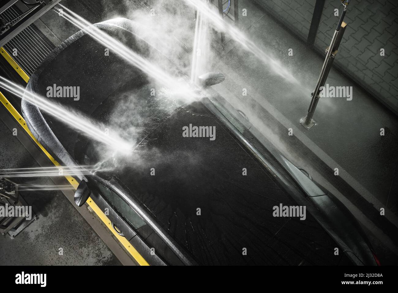 Modern Car under High Pressure Washing System Inside Touchless Car Wash
