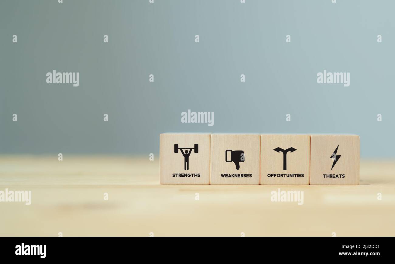 Concept of SWOT analysis and strategic planning technique. Strengths, weaknesses, threats and opportunities of company. SWOT symbols on wooden cubes w Stock Photo