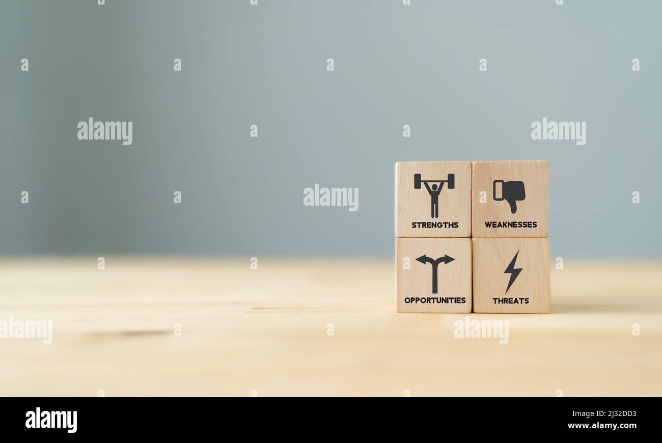 Concept of SWOT analysis and strategic planning technique. Strengths, weaknesses, threats and opportunities of company. SWOT symbols on wooden cubes w Stock Photo