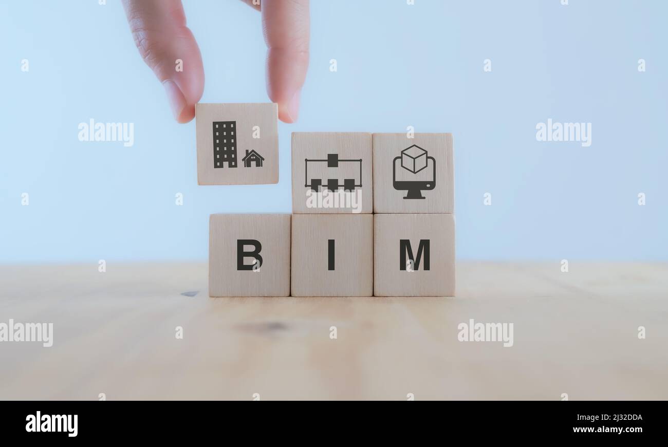 BIM Building Information Modeling.  Industry construction, from start to finish. Planner puts wooden cube  with symbol; construction model, informatio Stock Photo
