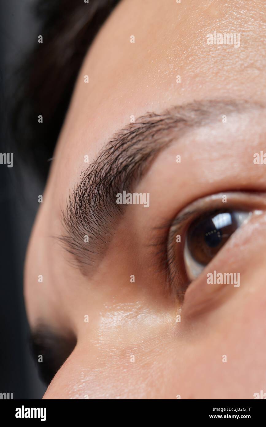 Professional barber doing threading procedure and correcting shape of