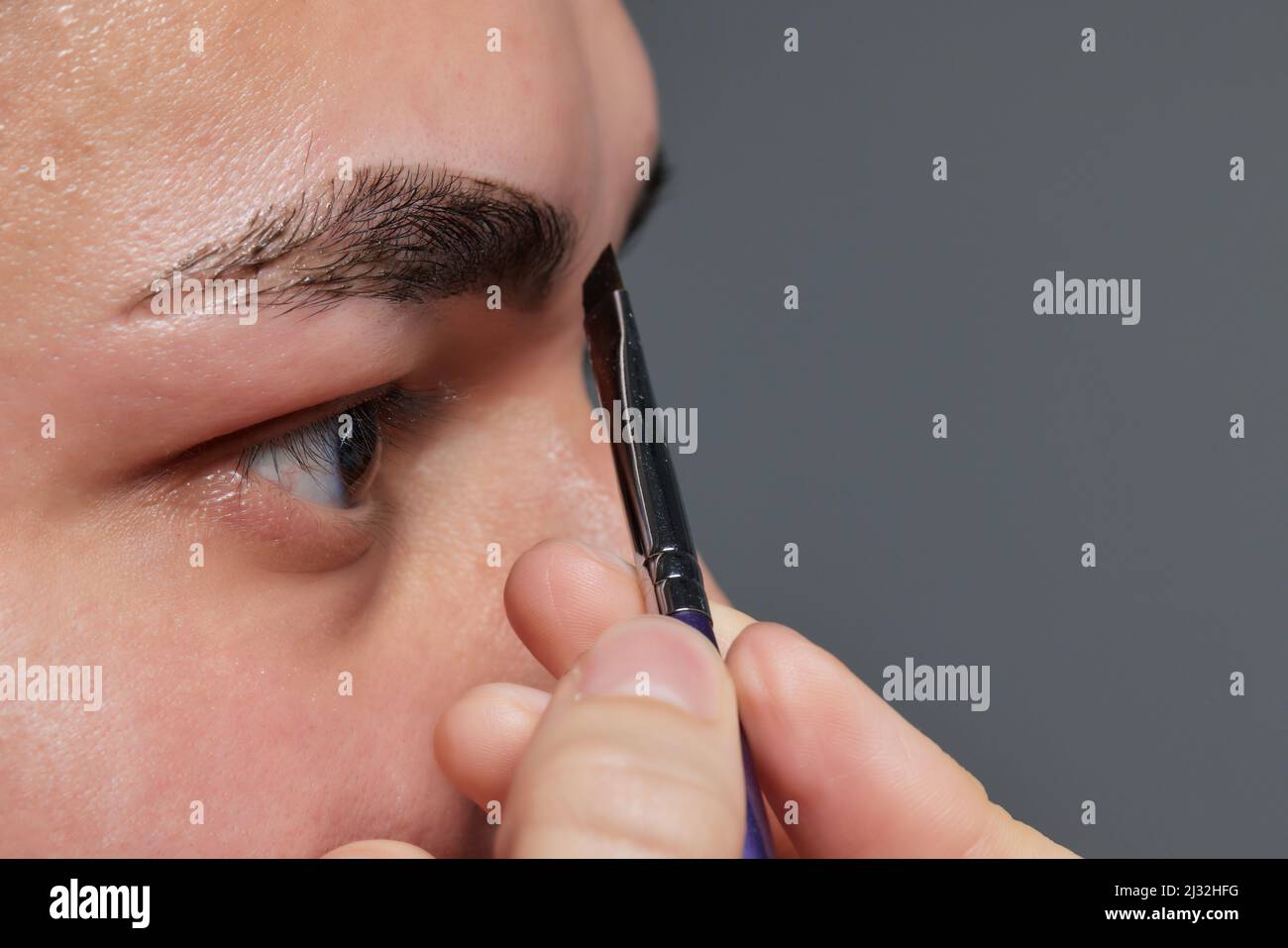 Professional barber doing threading procedure and correcting shape of