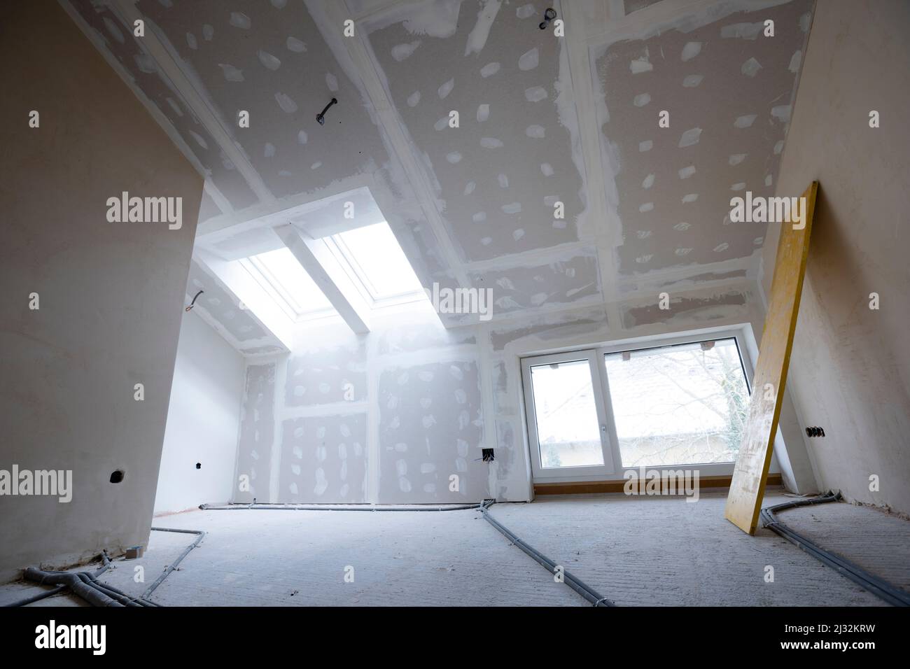 Attic finishing construction site in the phase drywall spackling and plastering before screeding