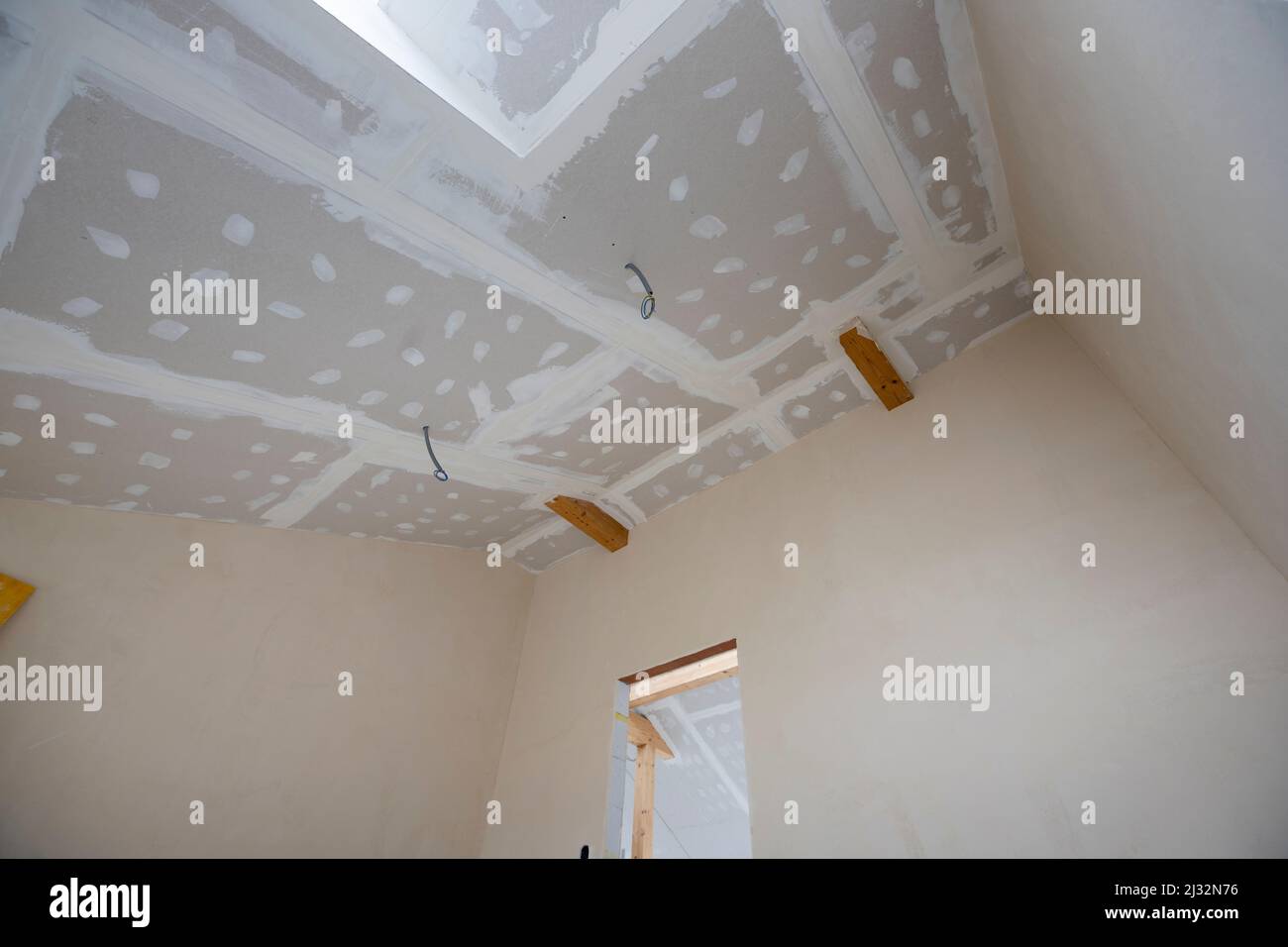 Attic finishing construction site in the phase drywall spackling and plastering before screeding