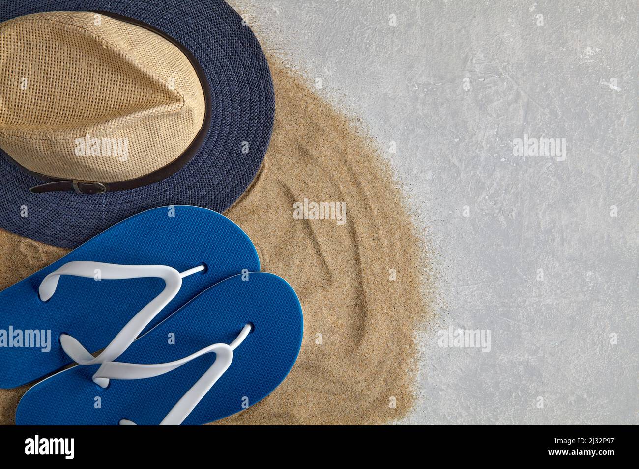 Straw hat, flip flops on scattered sea sand Stock Photo - Alamy