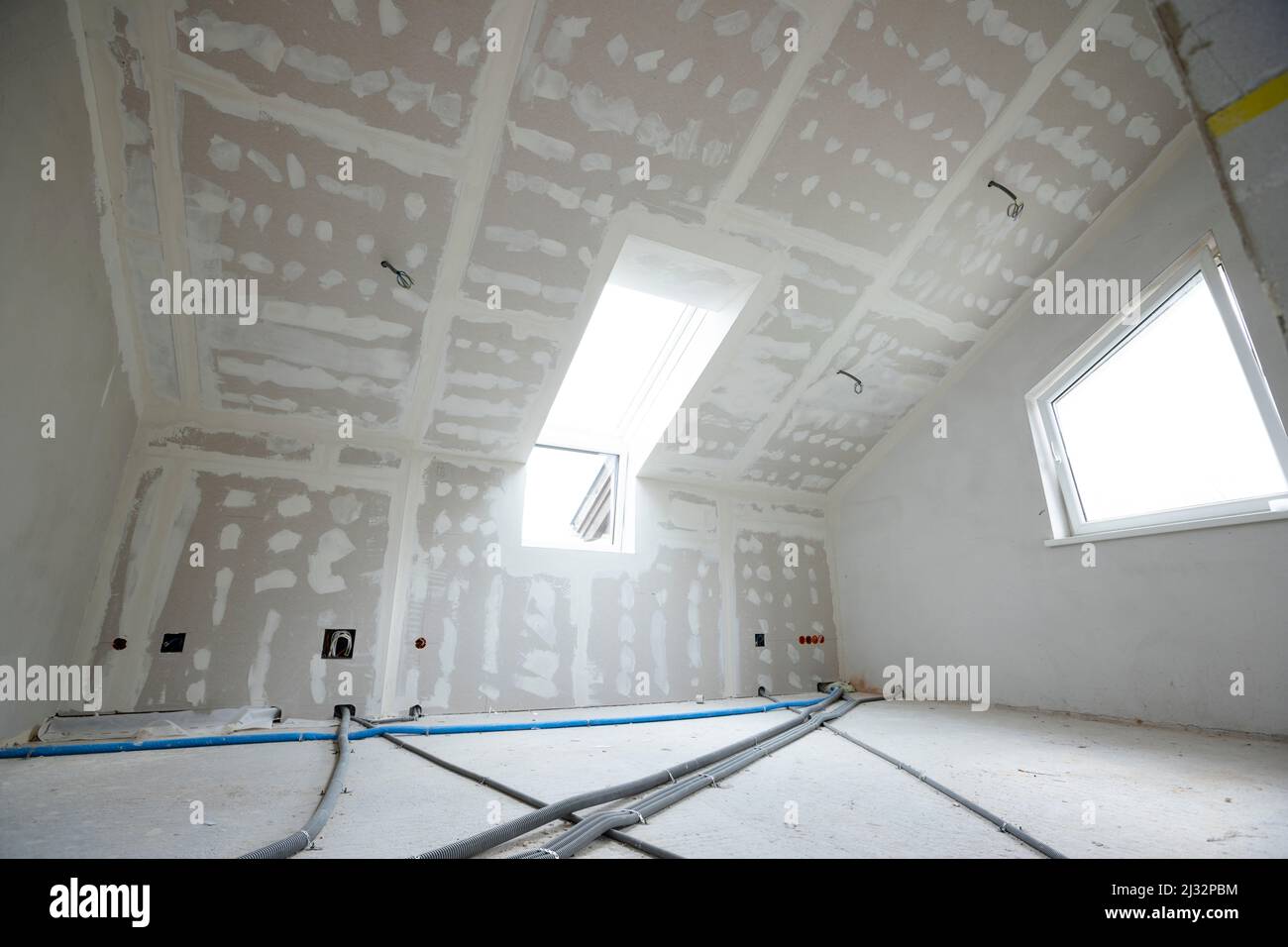 Attic finishing construction site in the phase drywall spackling and plastering before screeding