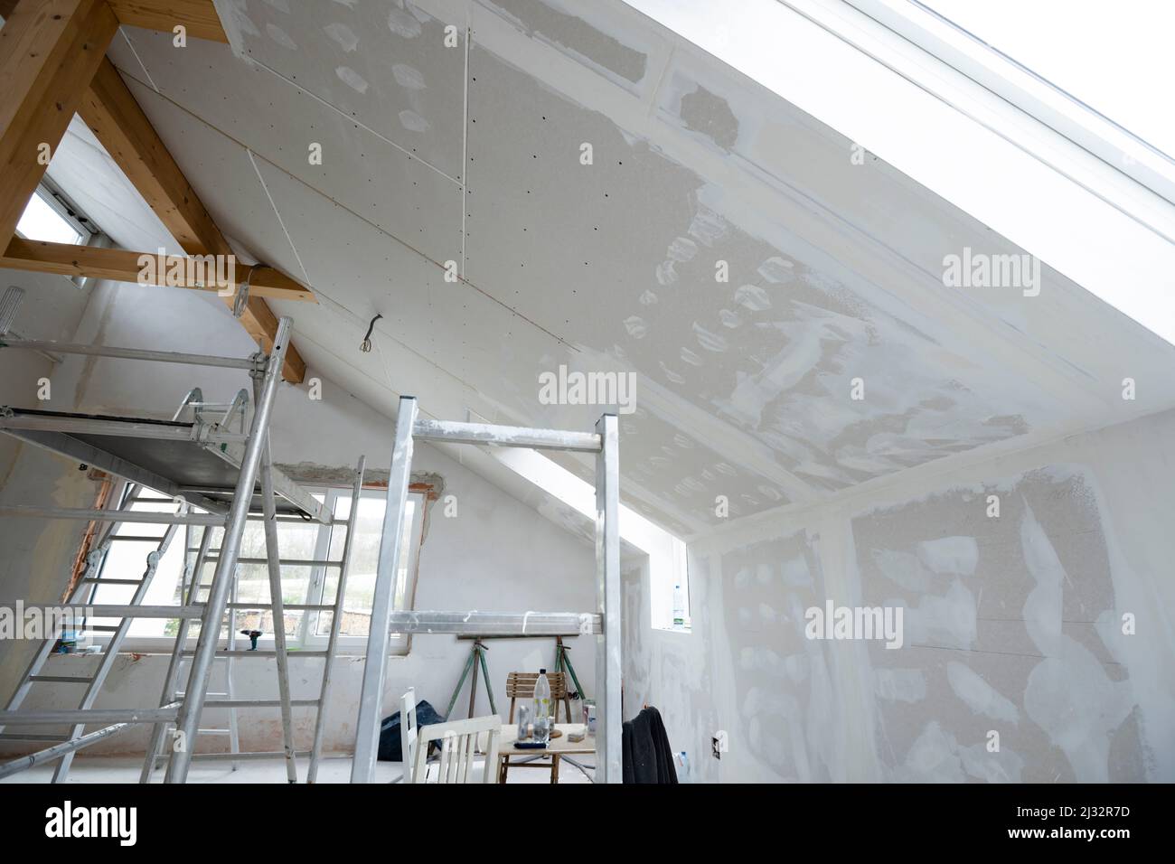 Attic finishing construction site in the phase drywall spackling and plastering before screeding
