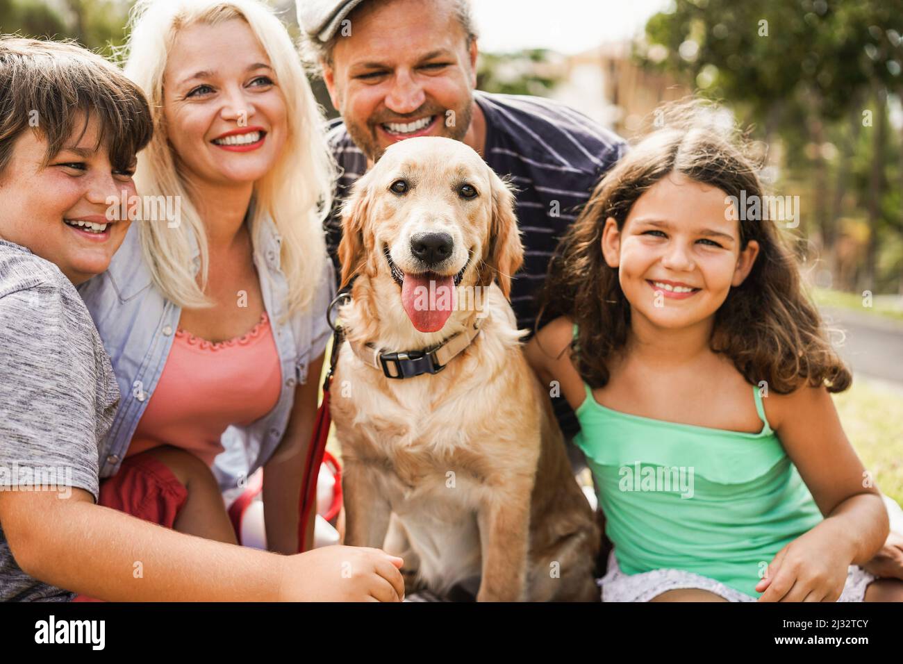 Happy family having fun with children and their dog outdoor summer time - Main focus on dog face Stock Photo