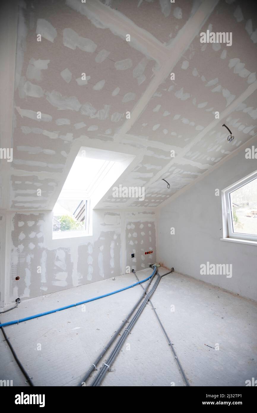 Attic finishing construction site in the phase drywall spackling and plastering before screeding