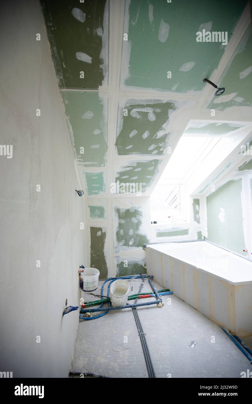 Attic finishing construction site in the phase drywall spackling and plastering before screeding
