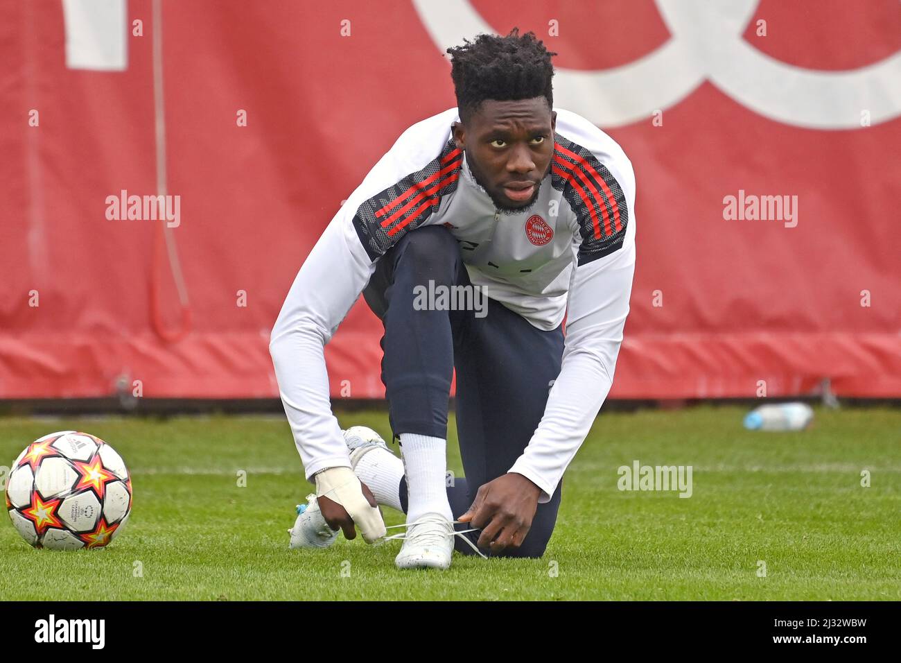 Munich, Deutschland. 05th Apr, 2022. Alphonso DAVIES (FC Bayern Munich)  laces up his football boots. Action, single action, single image, cut out,  full body shot, whole figure FINAL TRAINING. Soccer Champions League/