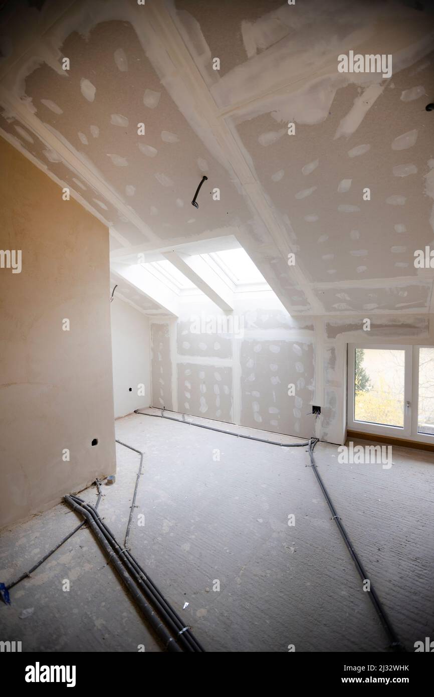 Attic finishing construction site in the phase drywall spackling and plastering before screeding