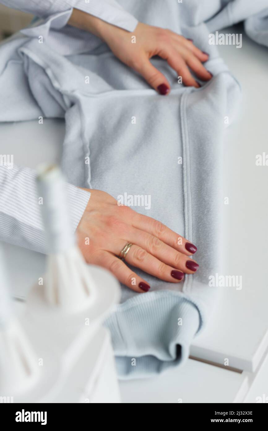 Seamstress look at ready clothes. Garment factory quality control check for defects. Tailors work Stock Photo Alamy