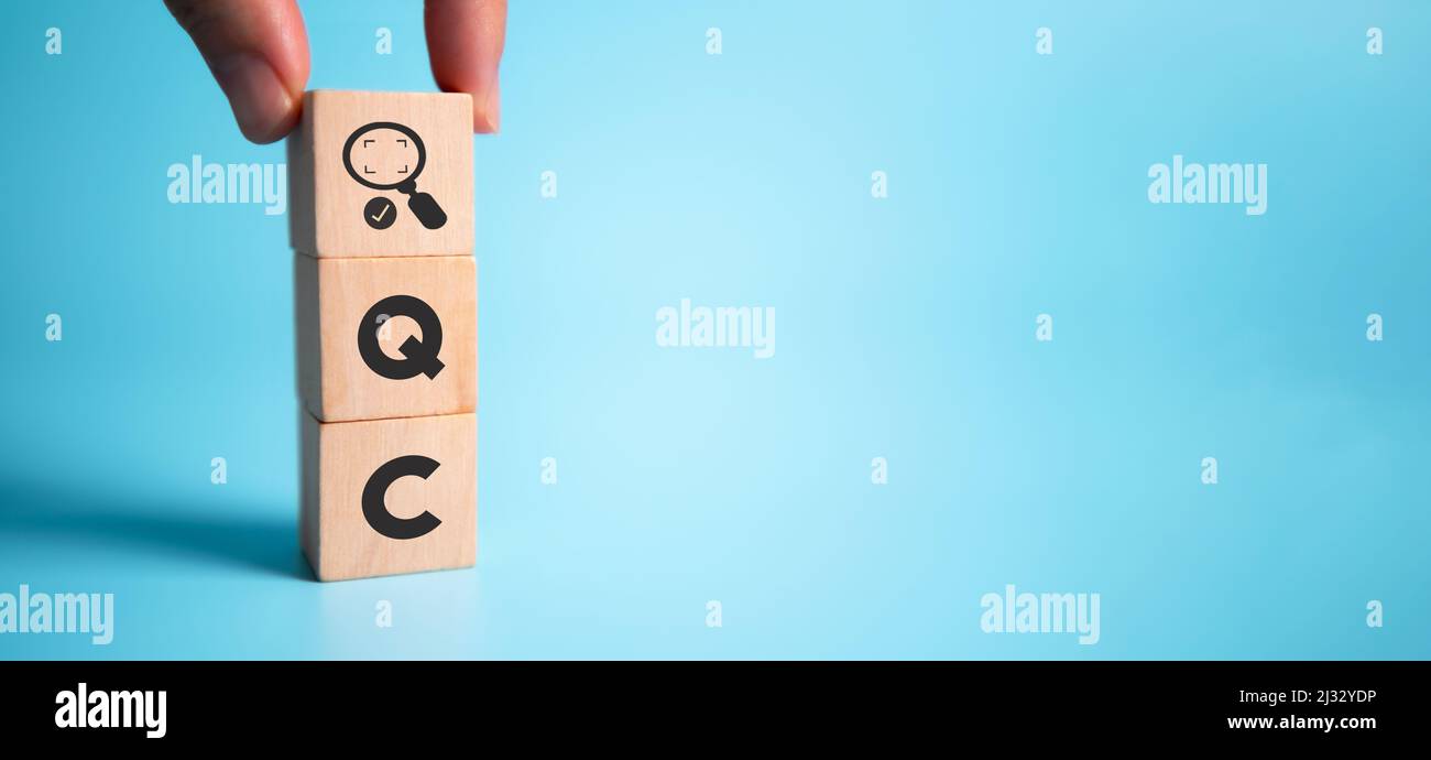 Quality control (QC) concept. For business and industry. Standard qulity,guarantee, process, check and approvement. Hand holds wooden cubes with appro Stock Photo