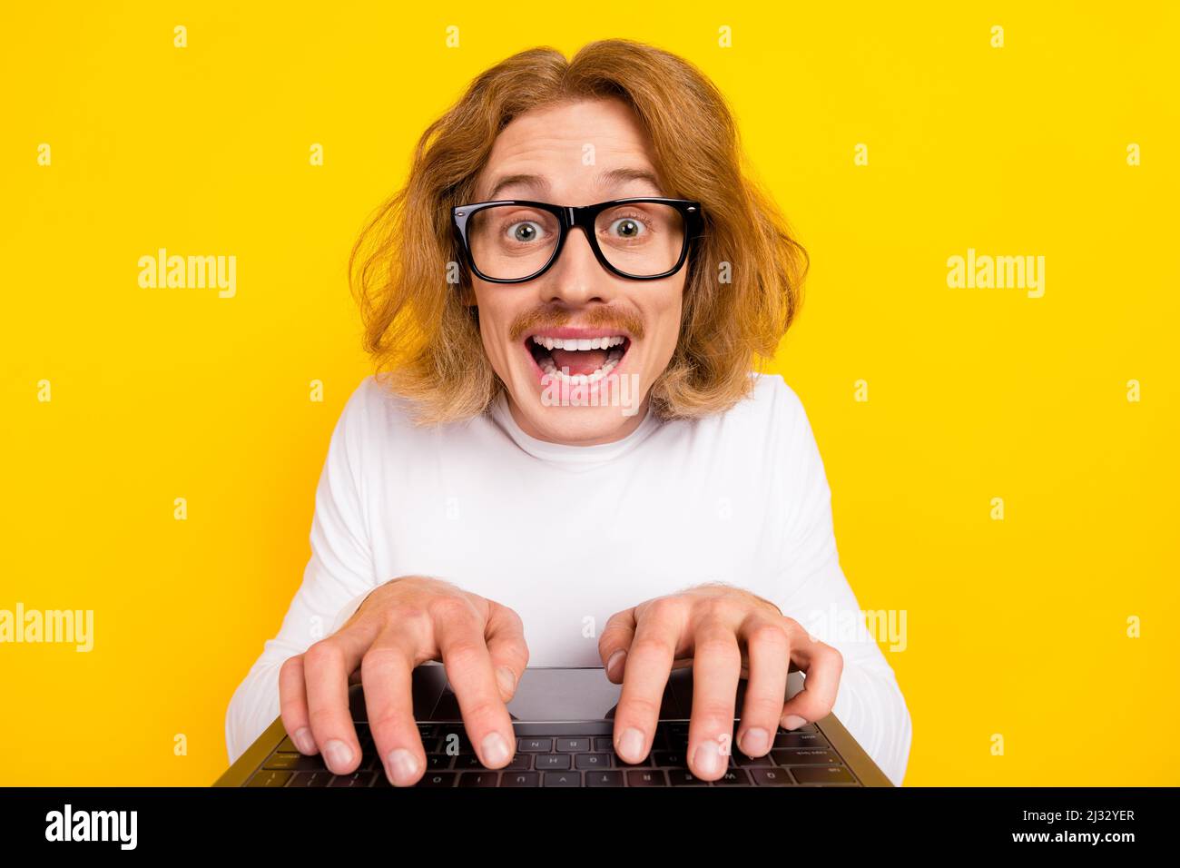 Photo of positive funky guy wear white shirt spectacles chatting modern gadget isolated yellow color background Stock Photo