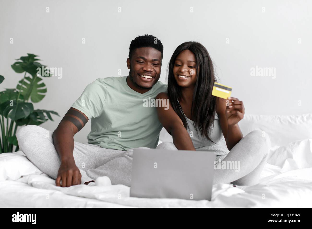 Cheerful young african american husband and wife looking at laptop and ...
