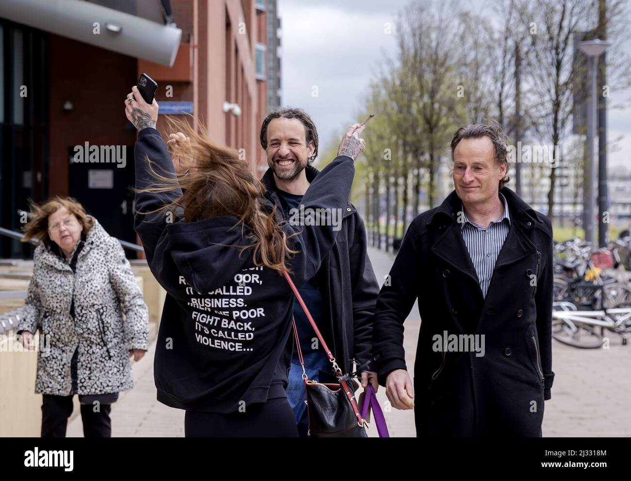 2022-04-05 14:30:05 ROTTERDAM - Willem Engel is welcomed by his girlfriend Dorien Rose when he leaves the court together with Jeroen Pols, the lawyer of Viruswaarheid, after his remand has been lifted. The foreman of Viruswaarheid was arrested again on April 3, after various media outlets published a conversation with Engel recorded in the studio of Café Weltschmerz. Engel's pre-trial detention was suspended on the condition that he would not make any statements on social media. ANP ROBIN VAN LONKHUIJSEN netherlands out - belgium out Stock Photo