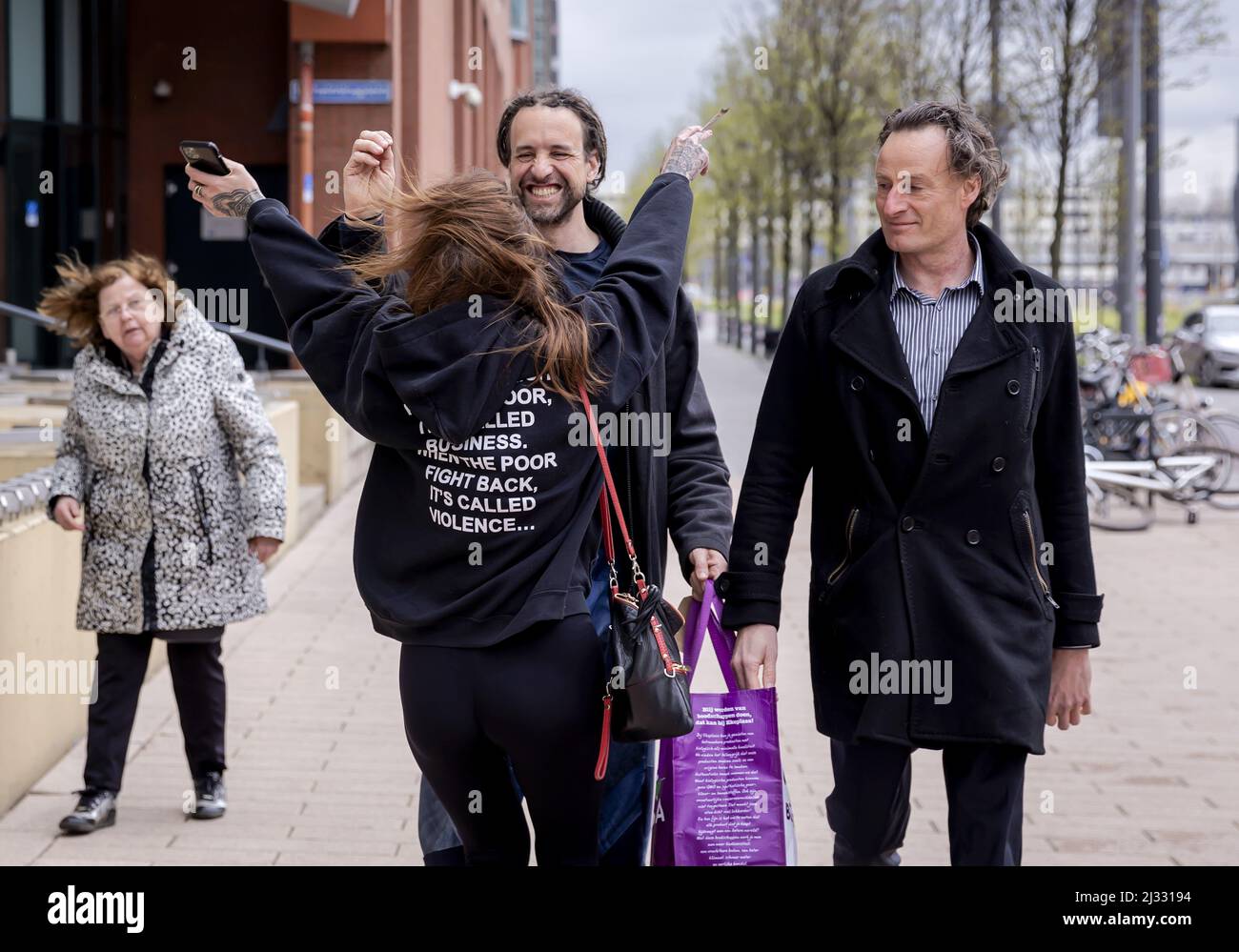 2022-04-05 14:30:05 ROTTERDAM - Willem Engel is welcomed by his girlfriend Dorien Rose when he leaves the court together with Jeroen Pols, the lawyer of Viruswaarheid, after his remand has been lifted. The foreman of Viruswaarheid was arrested again on April 3, after various media outlets published a conversation with Engel recorded in the studio of Café Weltschmerz. Engel's pre-trial detention was suspended on the condition that he would not make any statements on social media. ANP ROBIN VAN LONKHUIJSEN netherlands out - belgium out Stock Photo