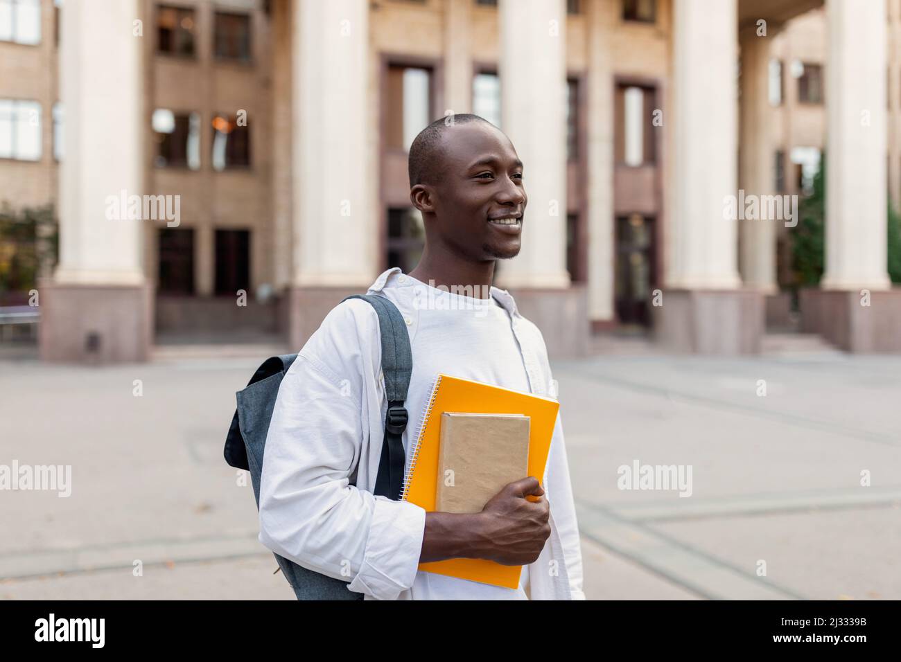 Smiling african american male student with backpack and workbooks ...