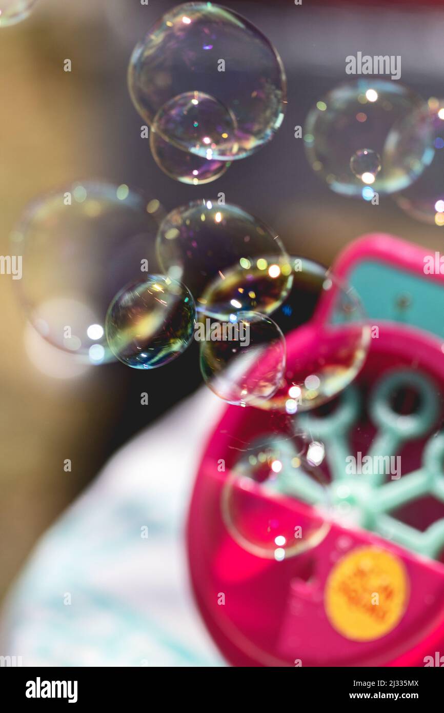 A bubble machine cranks out bubbles at an outdoor party. Stock Photo