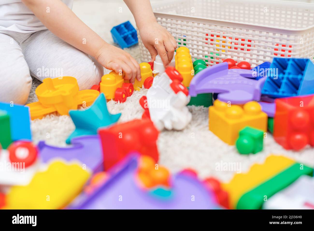 The child collects a multi-colored constructor. Stock Photo