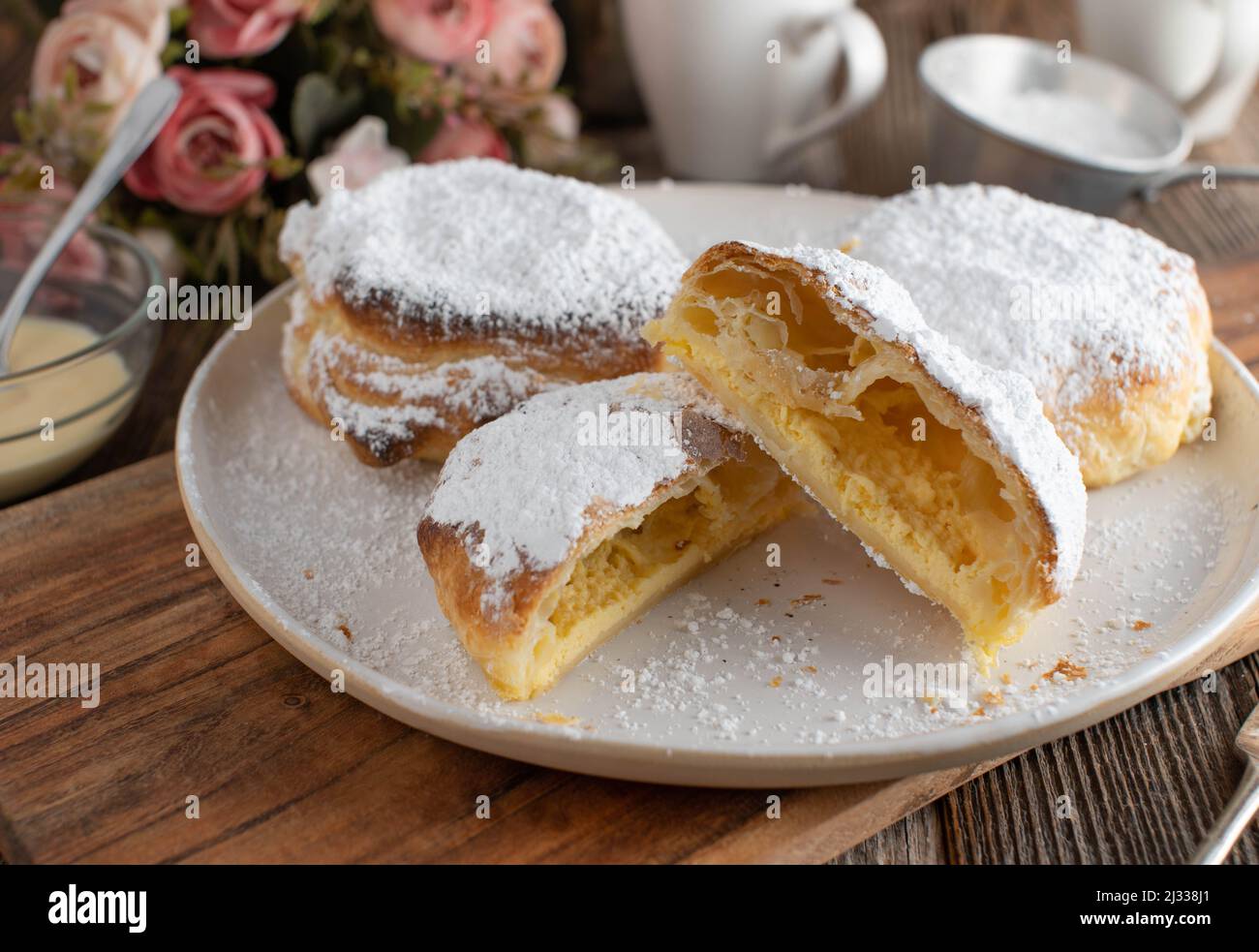 Puff pastry pockets filled with delicious sour cream filling served as a dessert on a coffee table Stock Photo