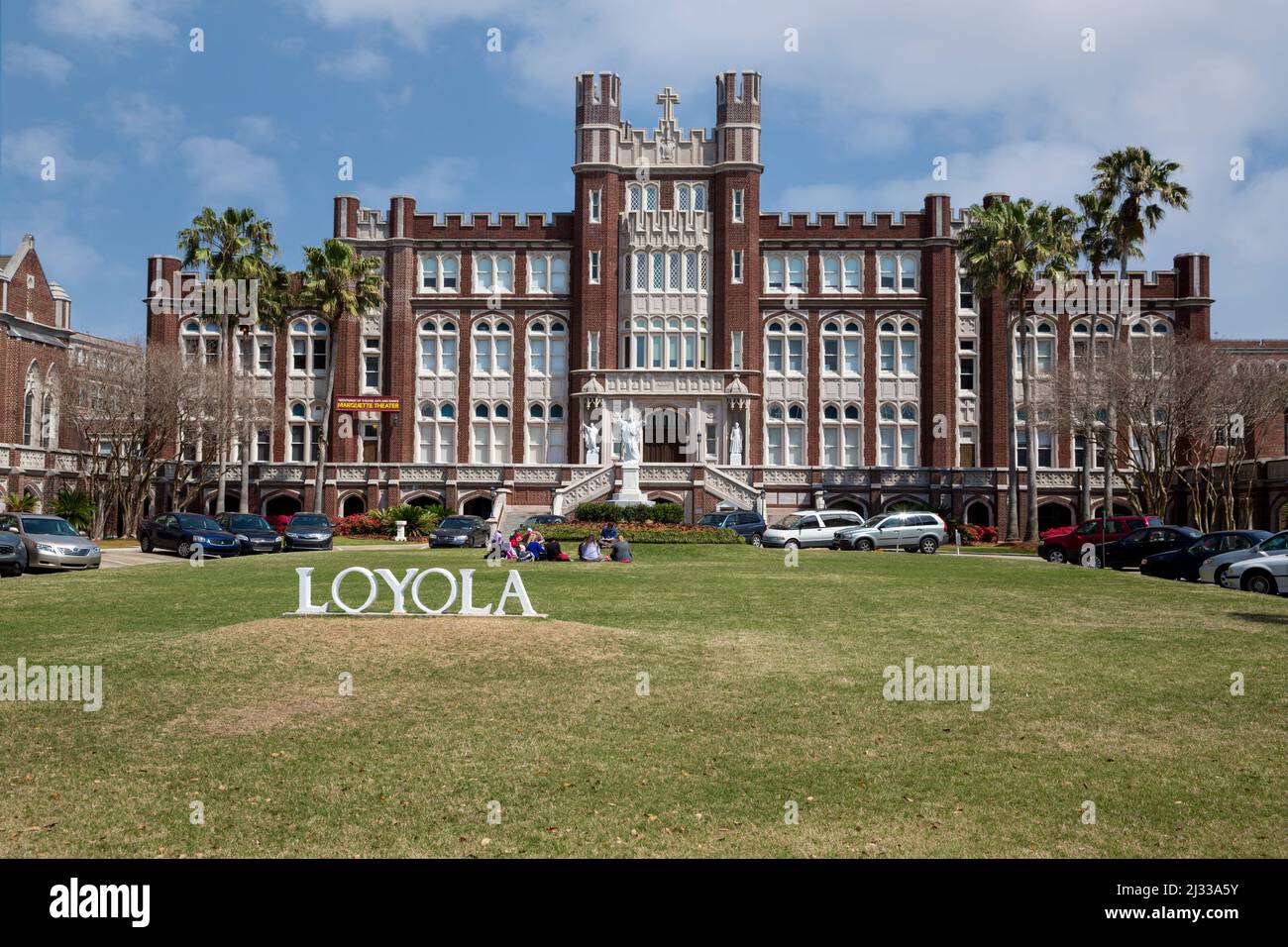 New Orleans, Louisiana.  Loyola University, Students Sitting on the Lawn, Marquette Hall behind them. Uptown District. Stock Photo