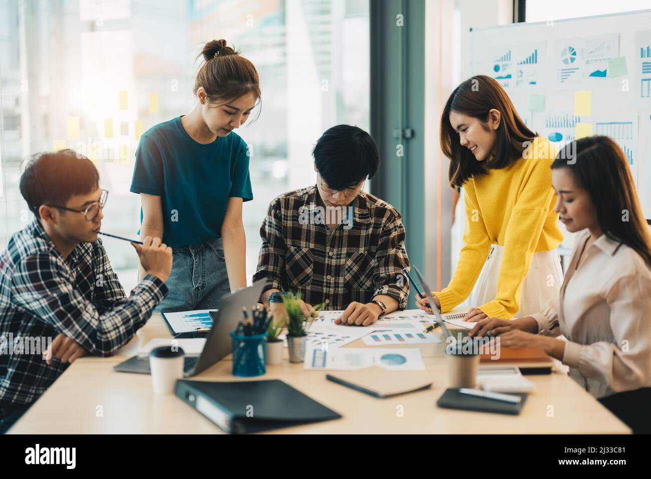 Group og young business asian people analyzing investment graph meeting brainstorming and discussing plan in meeting room, investment concept Stock Photo