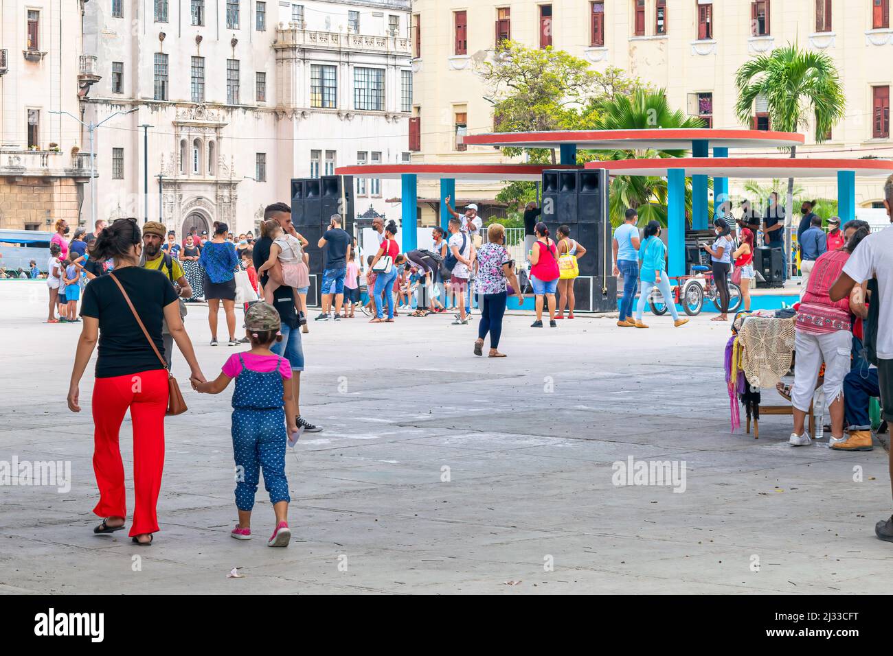 Cuban people and children partaking in a cultural activity in a public park. There are a music group and entertainers in the stage. The scene is commo Stock Photo