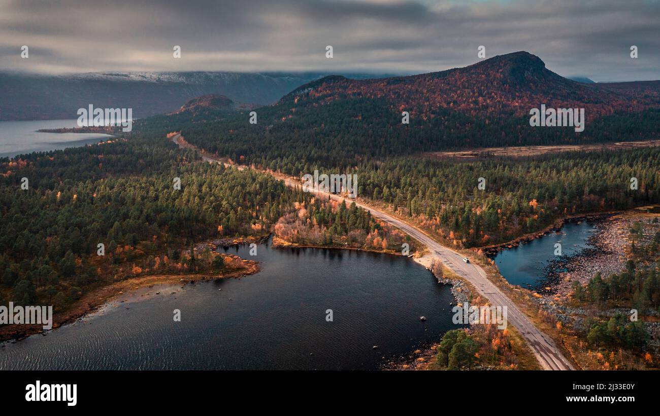 Road through landscape with lake and mountains in Stora Sjöfallet National Park in autumn in Lapland in Sweden from above Stock Photo