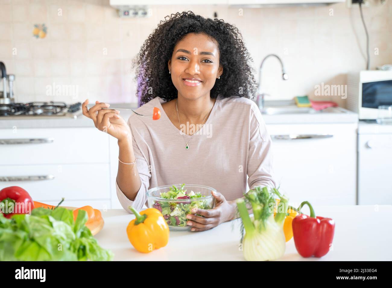 One black woman preparing vegetables salad at home Stock Photo