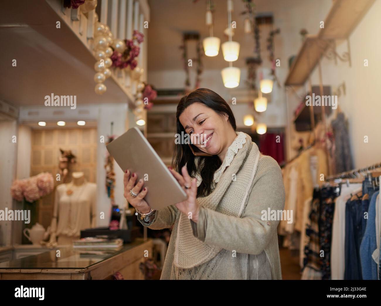 Tracking deliveries. Cropped shot of an attractive mature female entrepreneur working on a tablet in her self-owned boutique. Stock Photo
