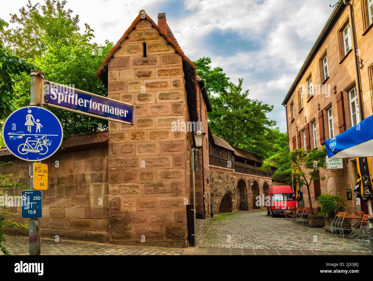 Great view into the road Spittlertormauer with its street sign and the famous medieval fortress walls with walkable battlements, part of the historic... Stock Photo