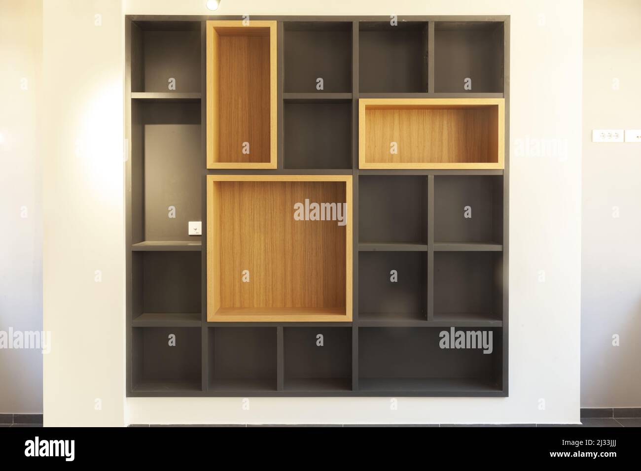 empty wooden shelves in the shape of cubes on the wall Stock Photo
