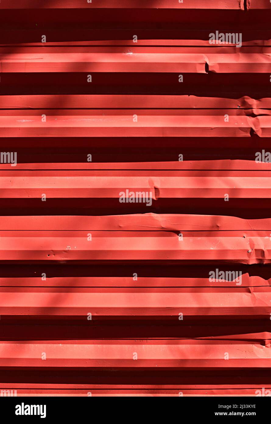 Red corrugated metal plate surrounding wasteland Stock Photo