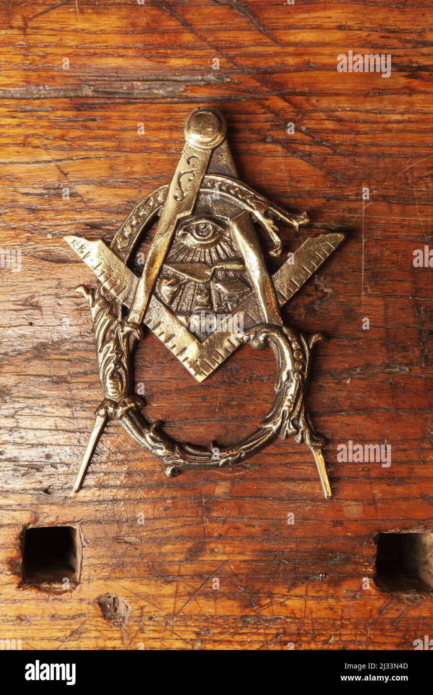 a metal rattle on a wooden door in the shape of a Masonic sign Stock Photo