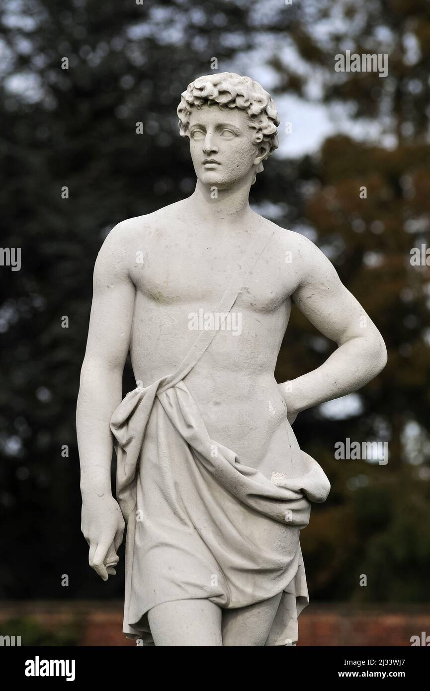 Neoclassical statue of handsome youth Adonis, Ancient Greek god of beauty and desire.  Stands in the Rose Garden at Hampton Court, the historic royal palace beside the River Thames, in the London Borough of Richmond-upon-Thames, England. Stock Photo