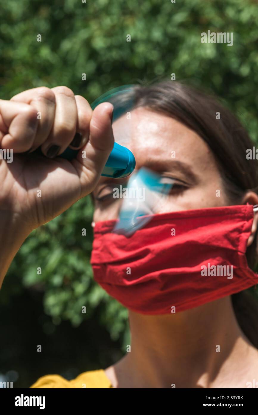 using hand held ventilator to cool down a virus protective face mask Stock Photo