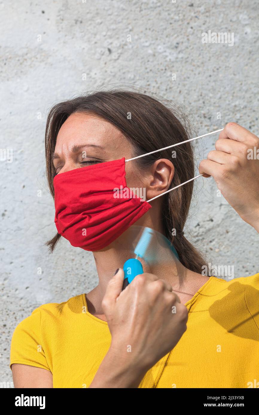 using hand held ventilator to cool down a virus protective face mask Stock Photo