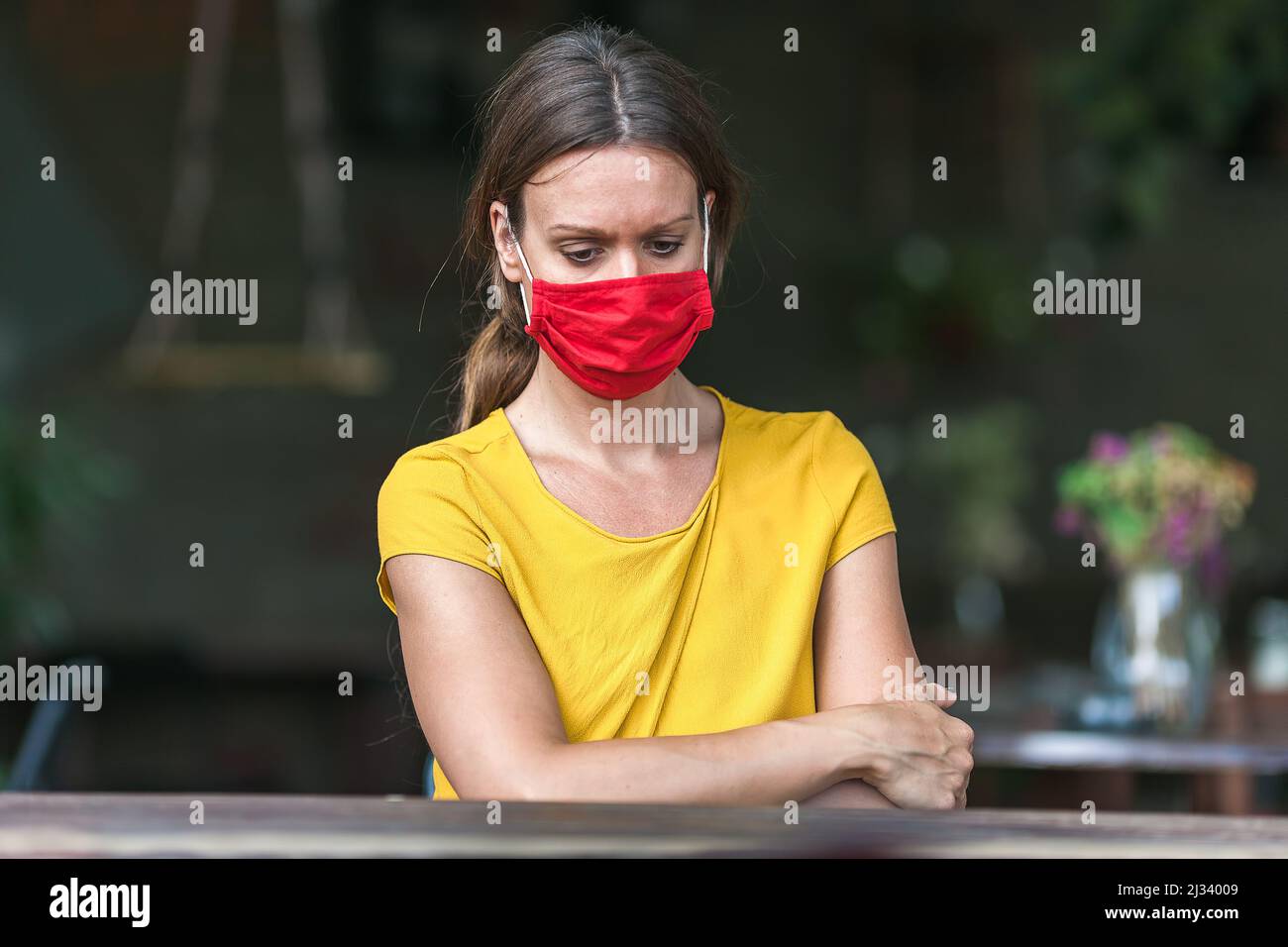 young woman wearing a face mask feeling depressed during coronavirus epidemic Stock Photo