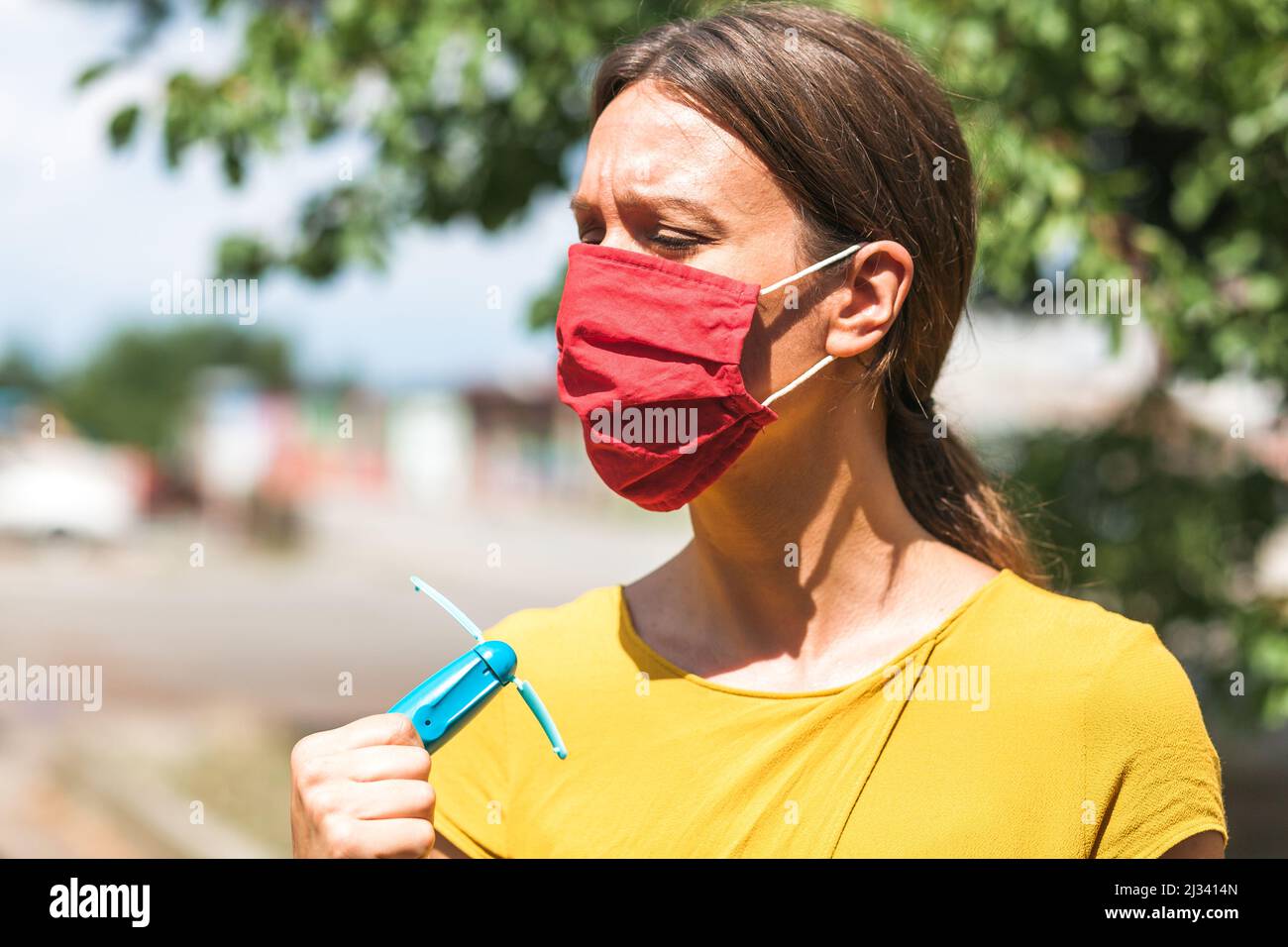 using hand held ventilator to cool down a virus protective face mask Stock Photo