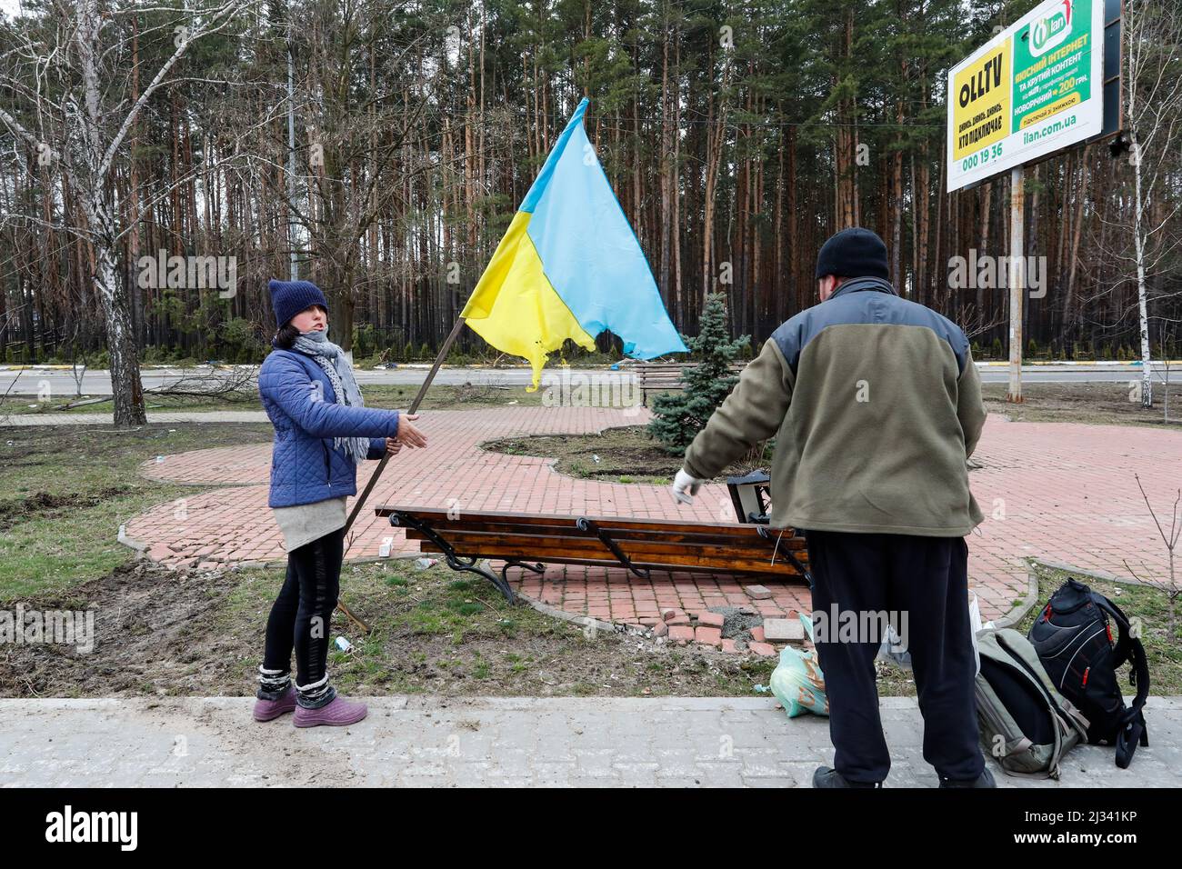 Bucha, Bucha, Ukraine. 5th Apr, 2022. A resident holds up a broken national flag of Ukraine in Bucha, as she and her relatives prepare to leave, after the Ukrainian forces recaptured the town from the Russian forces, amid the Russian invasion. (Credit Image: © Daniel Ceng Shou-Yi/ZUMA Press Wire) Stock Photo