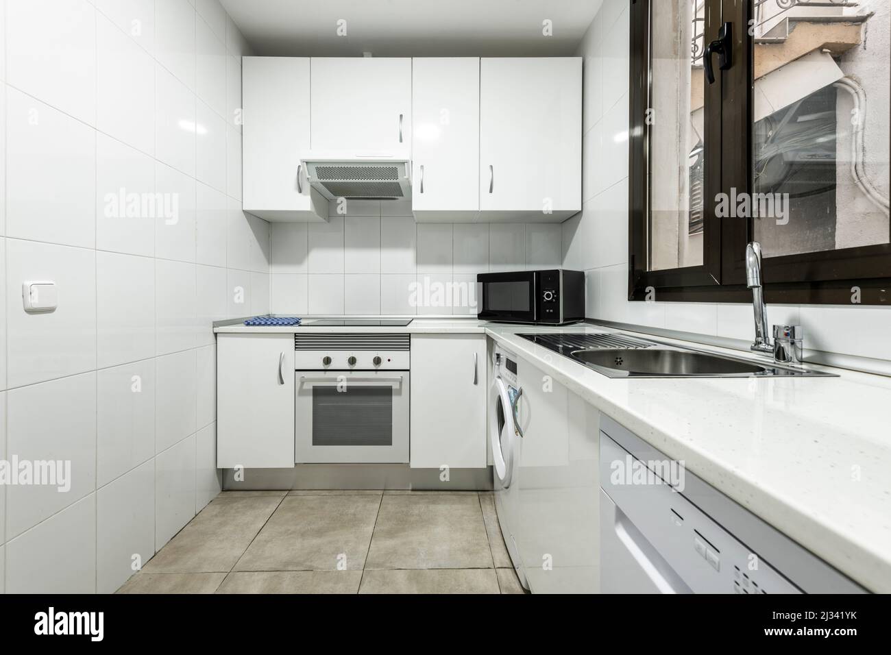 Lshaped kitchen with white and white stone countertops