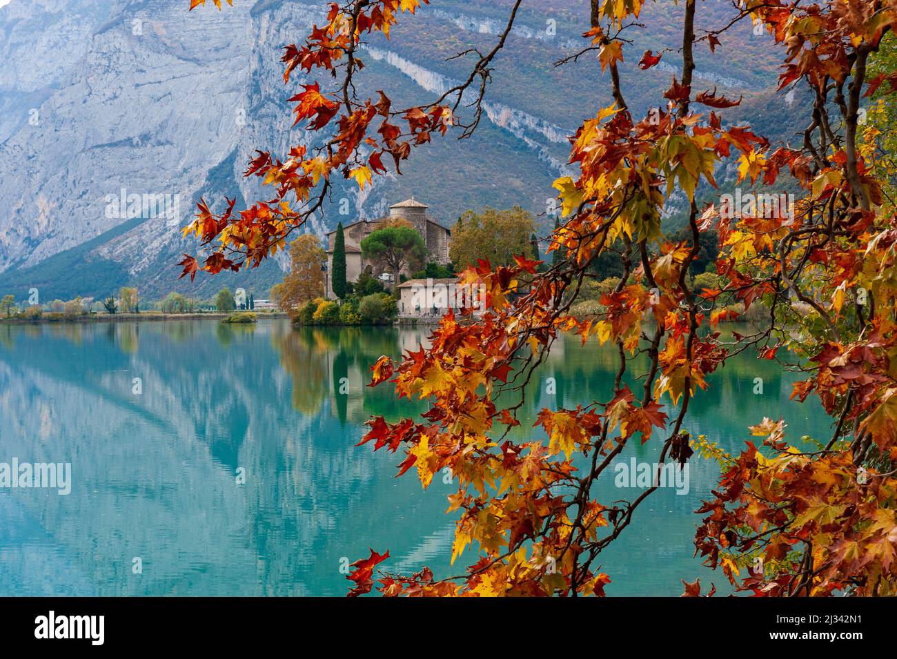 Lake Toblino with the castle in autumnal guise. It is a small Alpine lake in the province of Trento (Trentino-Alto Adige) and has been declared a Biotope for its naturalistic qualities. Location used for film production. Italy Stock Photo